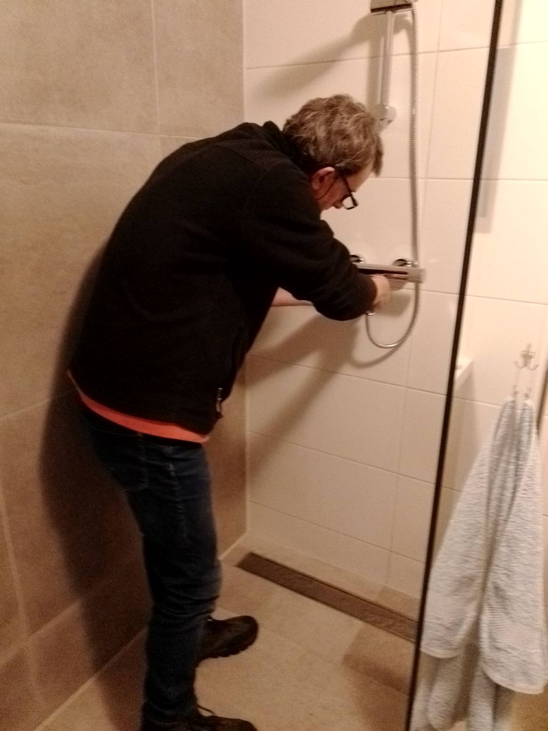 Robert monteert een thermostatische douchekraan in een betegelde douche