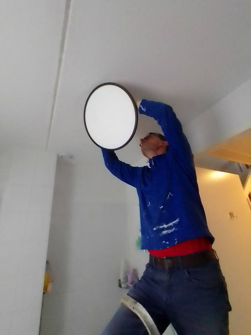 Jeroen monteert een ronde plafondlamp in de badkamer